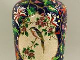 un vase avec un oiseau posé sur une table