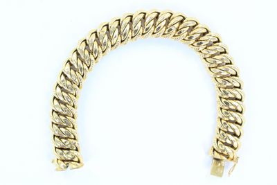 gros plan d'un bracelet en or sur fond blanc