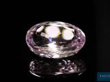 une image représentant un diamant rose posé sur une surface noire
