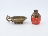 a small vase next to a small bowl on a white surface
