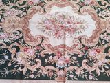 a green and pink rug with a floral design on it