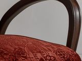 a close up of a chair with a red upholstered seat