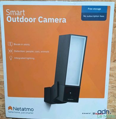 the box of a smart outdoor camera sits on a wooden surface