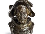 un buste en bronze représentant un homme coiffé d'un chapeau