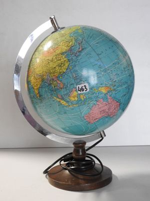 un globe terrestre posé sur un socle, sur une table