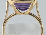 a close up of a ring with a purple stone in it