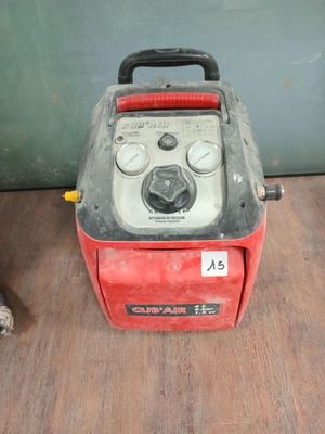a red and black machine sitting on a wooden floor