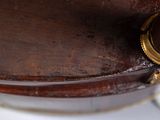 a close up of a wooden bowl with a gold ring on it