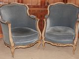 une paire de fauteuils en velours bleu dans une pièce aux murs lambrissés