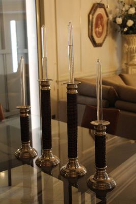 trois bougies posées sur une table en verre dans un salon