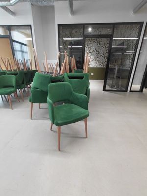 de nombreuses chaises vertes dans une grande pièce dotée d'une baie vitrée