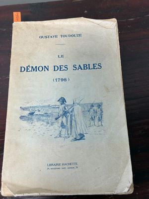 an old book sitting on top of a table next to a wooden table