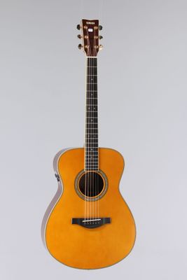 an orange acoustic guitar sitting on top of a white surface