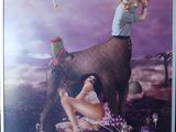 a picture of a man and a woman sitting on a cow