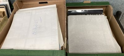 Deux boîtes remplies de papiers sont posées sur une table dans une pièce.