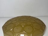 yellow glass plate with a decorative design on it on a white surface
