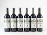 six bouteilles de vin sont alignées sur une surface blanche