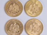 four different types of gold coins sitting on top of a white surface