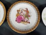 three plates with gold rims are sitting on a black table