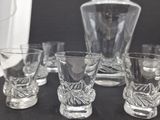 four glasses and a decanter sitting on a table