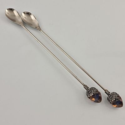 deux cuillères et une cuillère reposent sur une surface blanche