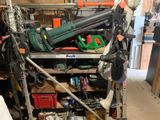 une photo d'un garage encombré avec des outils sur les étagères