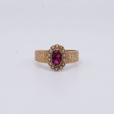un gros plan d'une bague en or sertie d'un rubis au centre