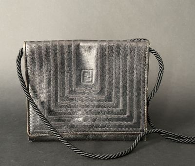 a silver purse sitting on top of a table next to a gray wall