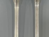 pair of silver plated spoons and a fork on a gray surface