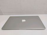 a silver apple laptop sitting on a white table