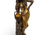 statue en bronze représentant une femme tenant un vase, posée sur un socle