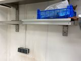 a small kitchen with a sink and a metal shelf