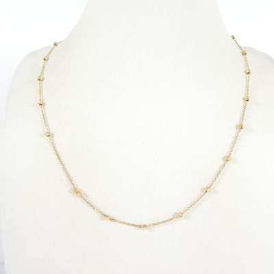 a gold chain necklace with pearls on a mannequin mannequin
