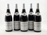 six bouteilles de vin rouge sont alignées sur une surface blanche