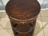 a small table with a wooden top on a tiled floor