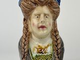 une figurine en céramique représentant une femme aux cheveux tressés