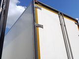 a white truck with a yellow stripe parked in front of a building