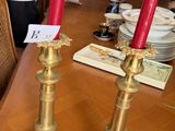 two candles that are sitting on a wooden table