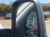 a side view mirror of a truck in a parking lot