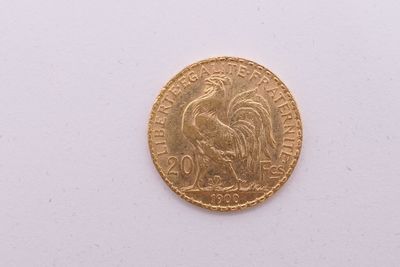 gros plan d'une pièce d'or sur une surface blanche