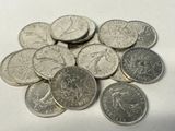 a pile of silver coins on a white surface