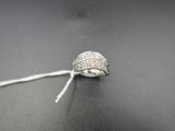 une image représentant une bague en argent posée sur une surface noire, accompagnée d'une étiquette
