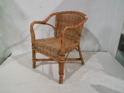 une chaise en osier posée sur une surface blanche