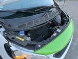 a green car with its hood open on the street