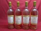 four bottles of wine are lined up on a red background