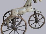statue représentant un cheval tirant une charrette à roues, avec une balle dans la bouche