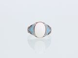 une bague en oplite blanche et topaze bleue sur un fond blanc