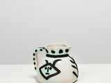 un vase blanc orné de motifs noirs et blancs, posé sur une table