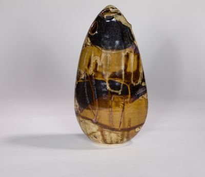 un gros plan d'un œuf en pierre marron et noir posé sur une surface blanche