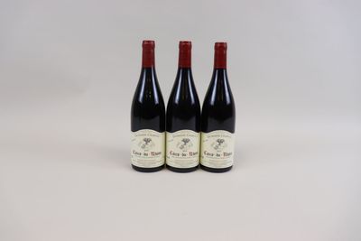 trois bouteilles de vin posées sur une table blanche